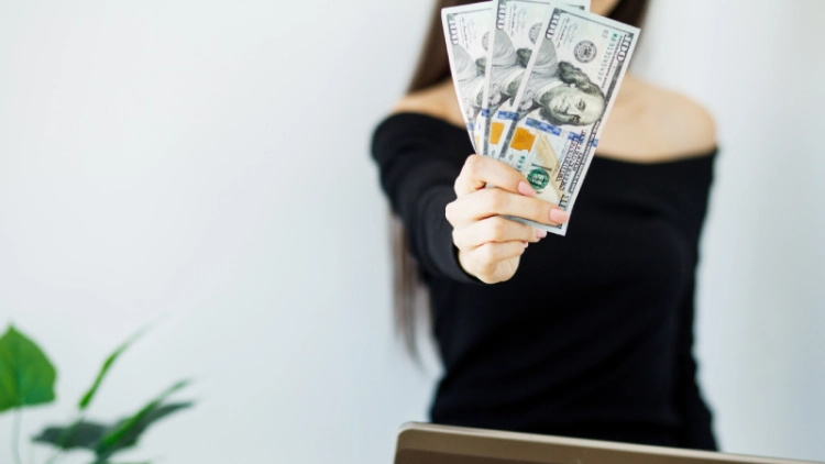 Woman With Money at Workplace. Business Concept.